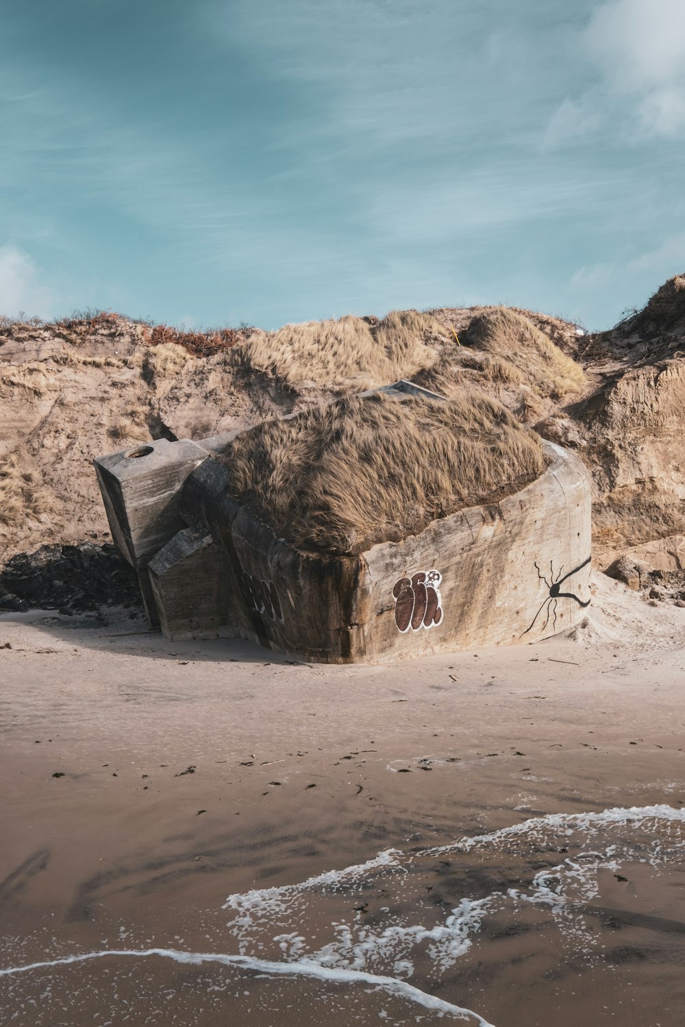 a large rock sitting on top of a sandy beach