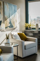 a living room filled with furniture and a painting on the wall