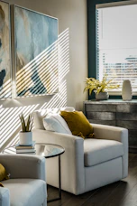 a living room filled with furniture and a painting on the wall