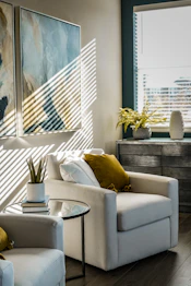 a living room filled with furniture and a painting on the wall