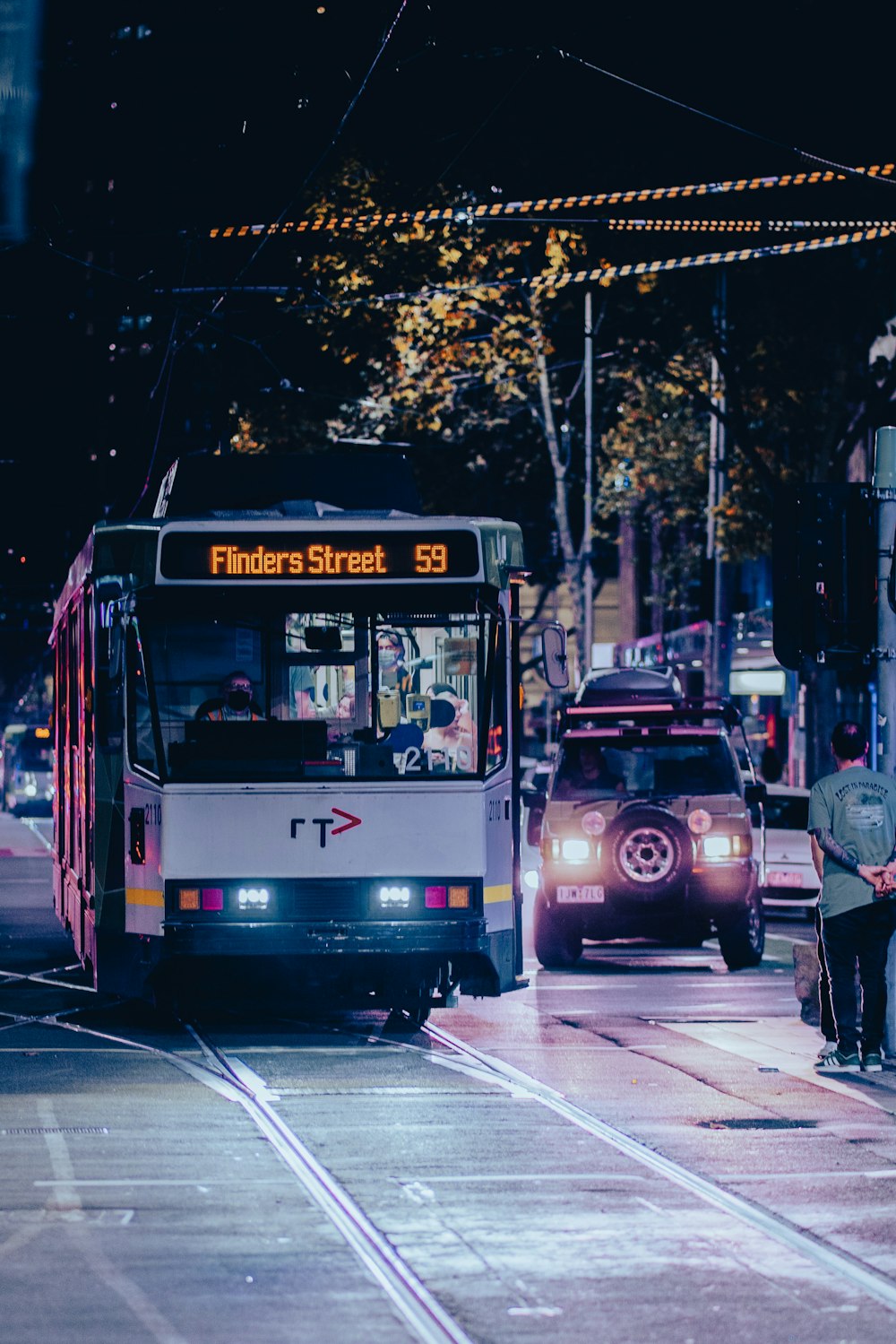 a bus and a car on a city street at night