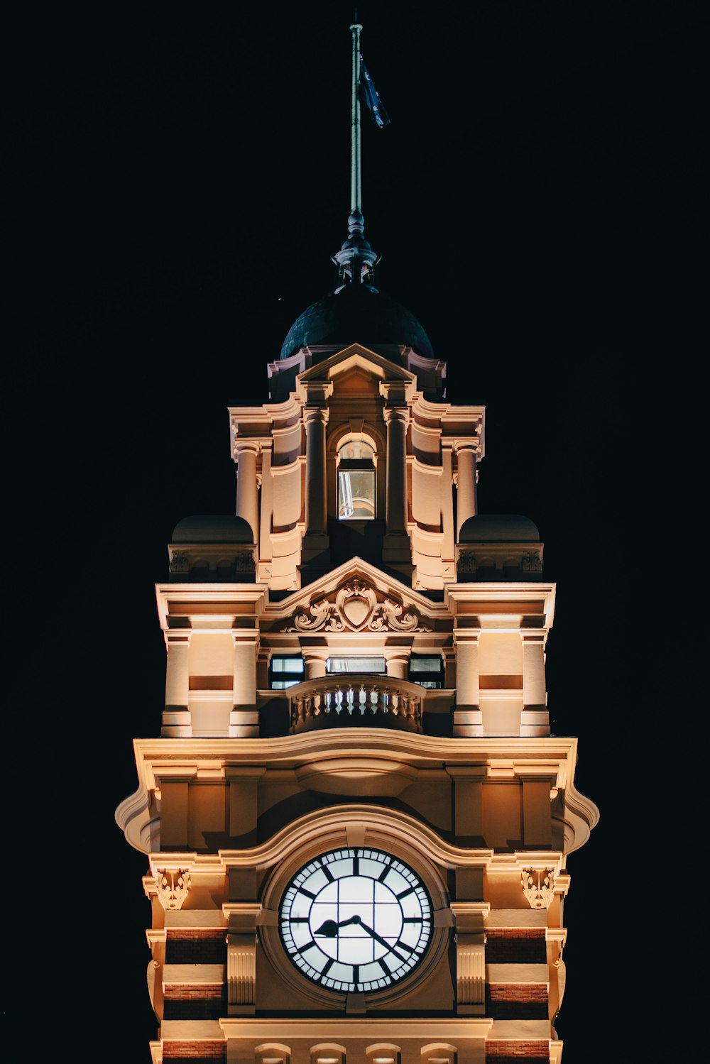 a clock tower lit up at night with a sky background