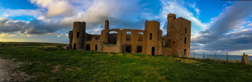 Un grande castello seduto in cima a un campo verde lussureggiante