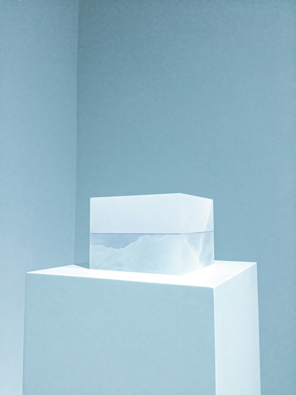 a white box sitting on top of a white pedestal