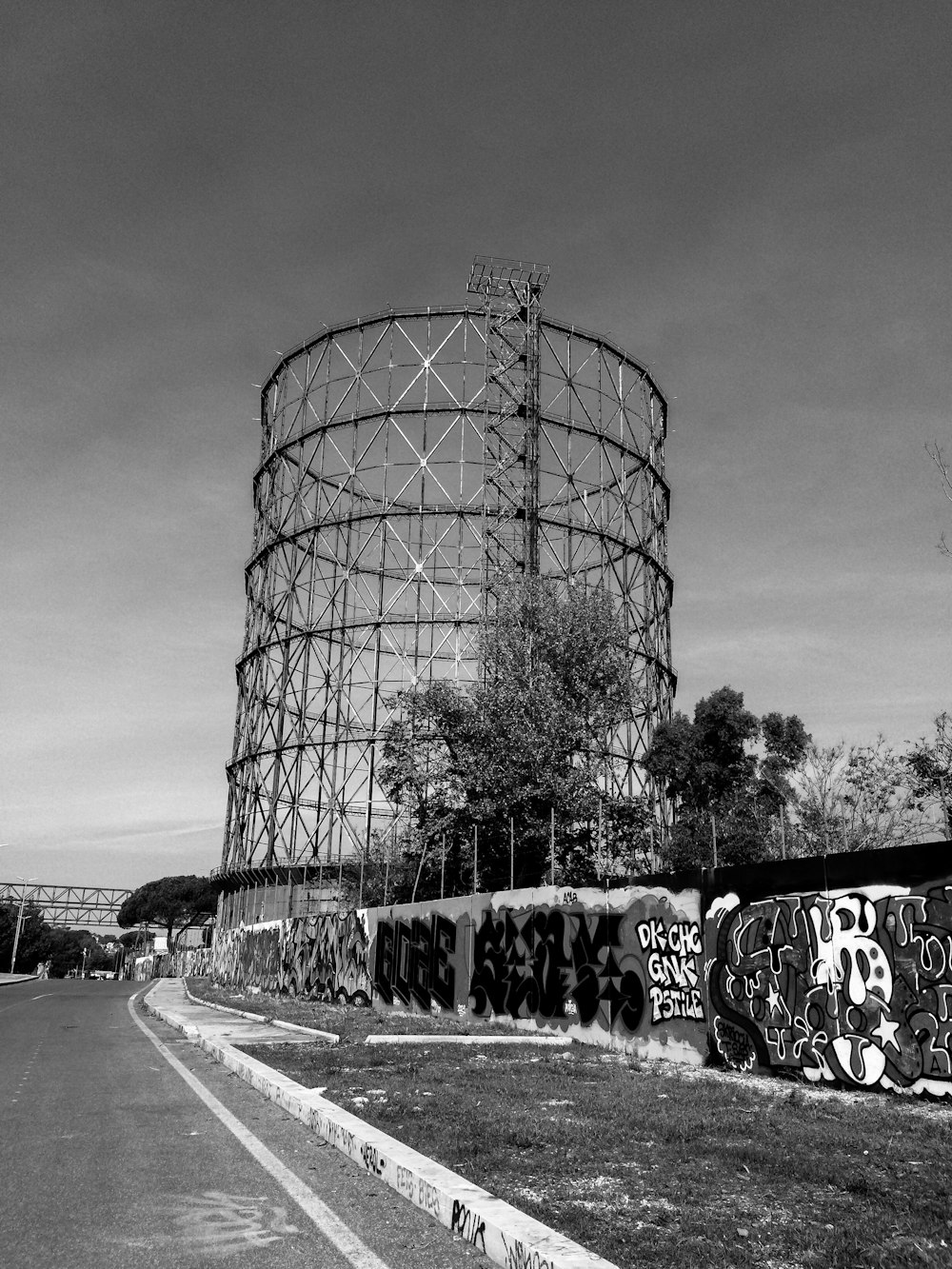 a black and white photo of graffiti on the side of a road