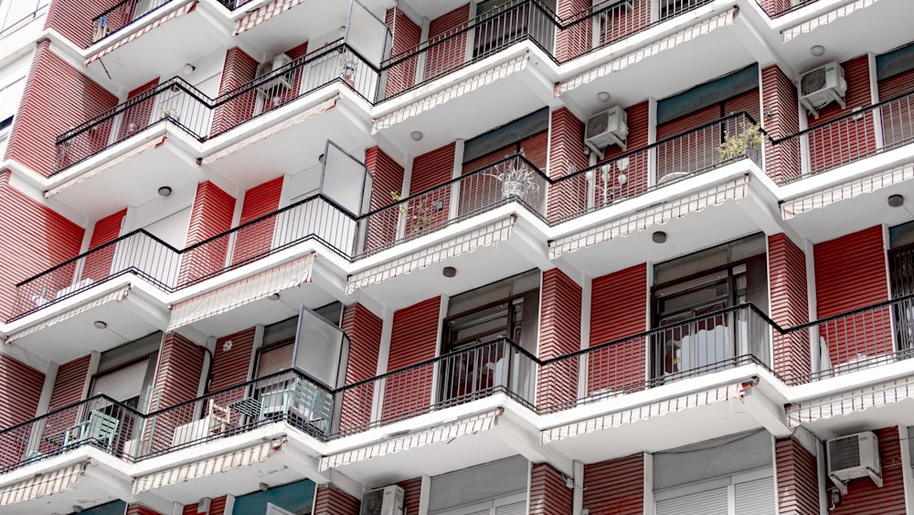 a tall red and white building with balconies