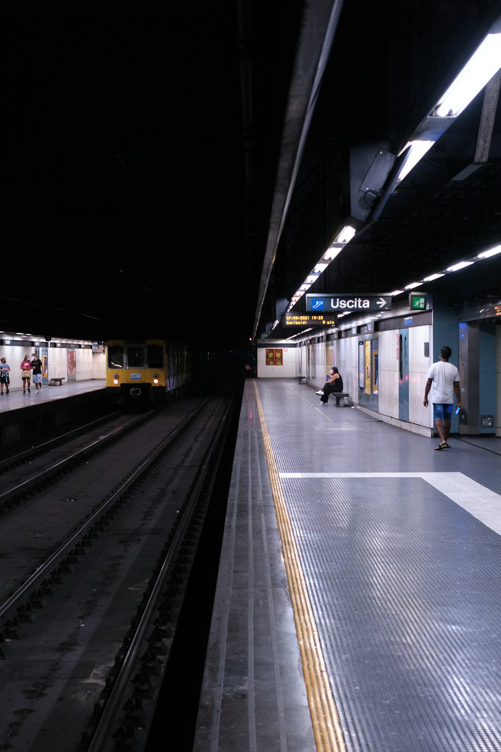 a train station with people waiting for the train