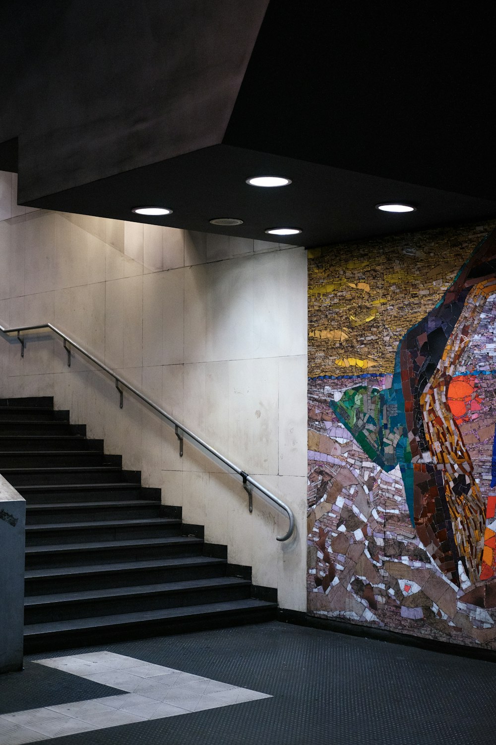 a staircase with a painting on the wall