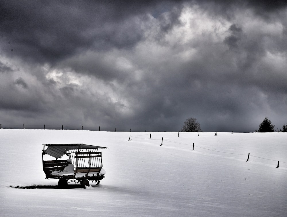 un piccolo carrello seduto sulla cima di un pendio innevato