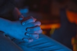 Close-up of hands in prayer over a glowing heart-shaped light