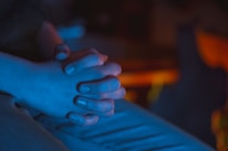 A close-up of hands in a meditative gesture surrounded by soft, natural light.