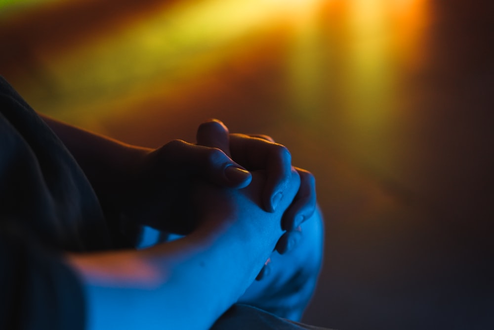 a close up of a person holding their hands together