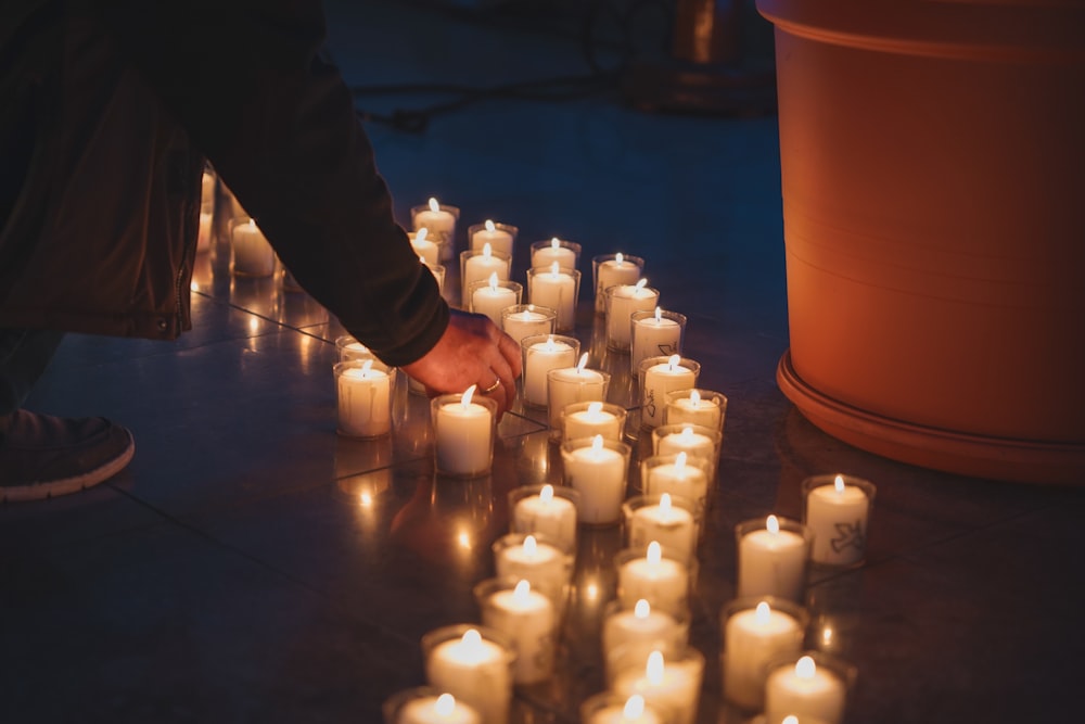 a person lighting candles on the ground