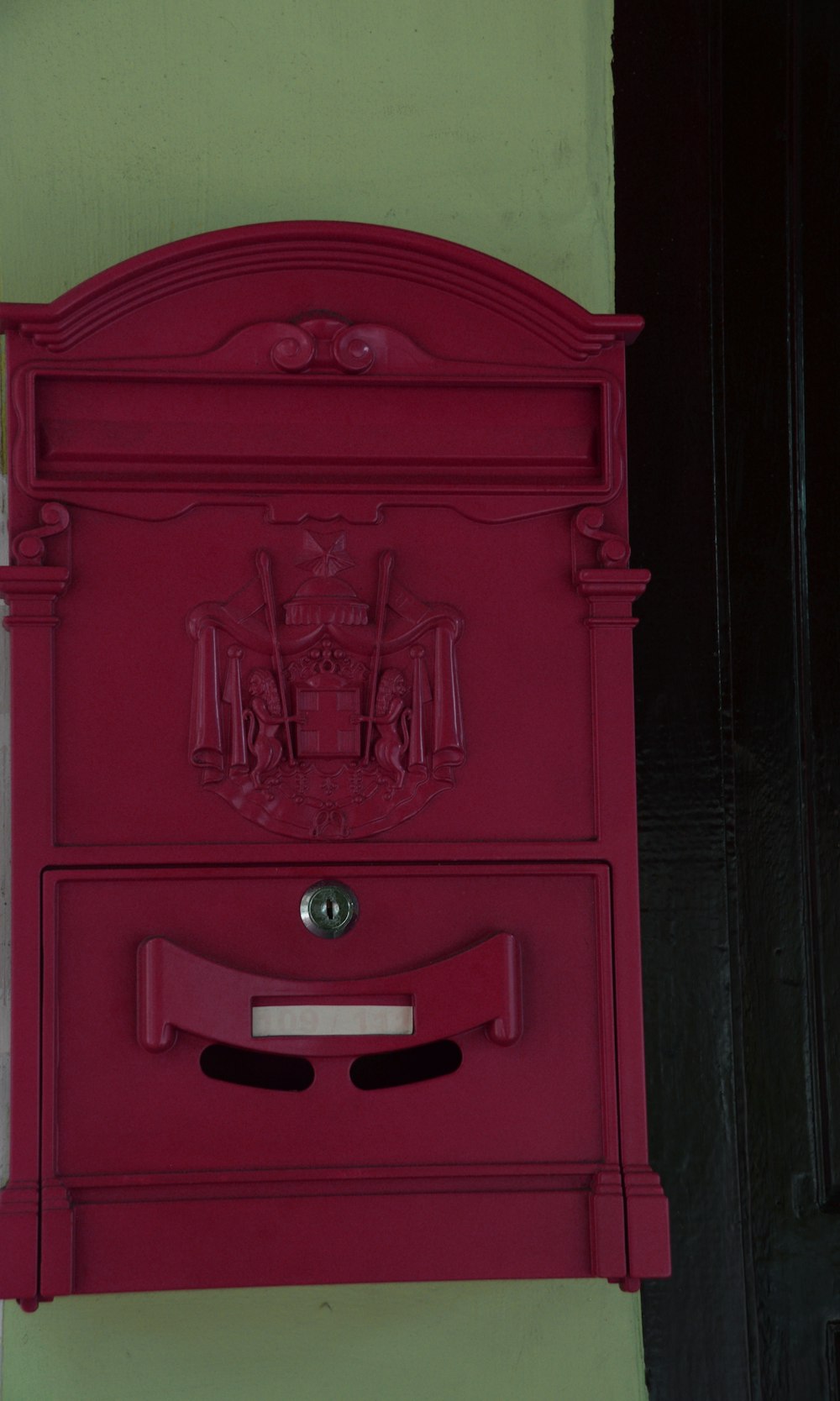 a red mailbox mounted to the side of a building