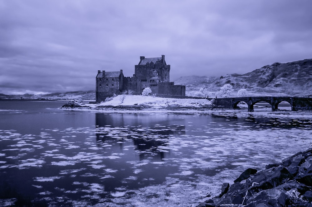 a castle sitting on top of a mountain next to a body of water