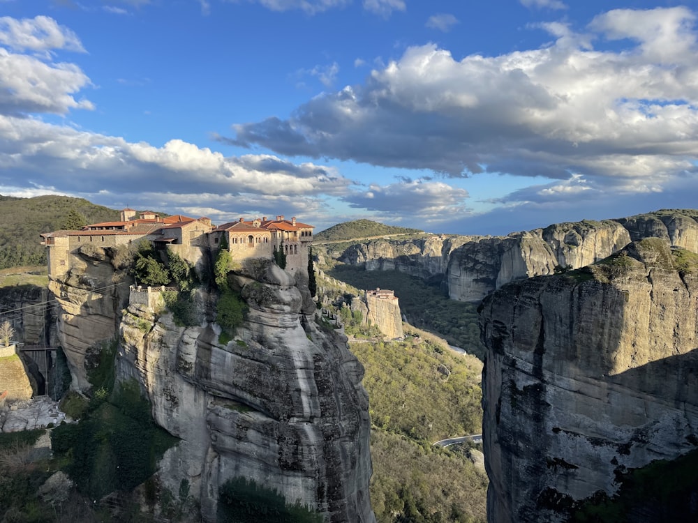 a castle perched on top of a cliff surrounded by mountains