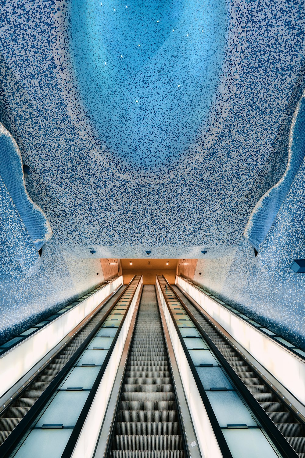 an escalator in a building with a sky background