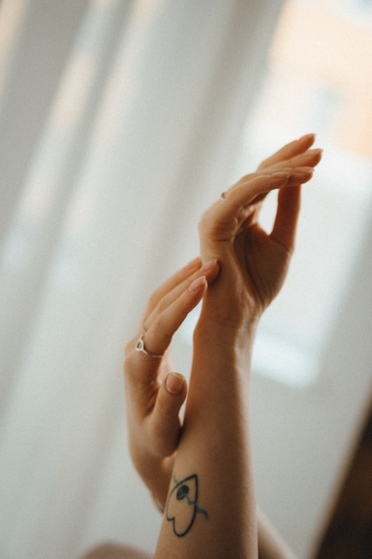 a woman with a smiley face tattoo on her arm