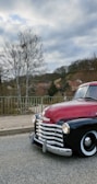 Classic Chevy Tahoe in racing red parked beside a Texas ranch fence at sunset.