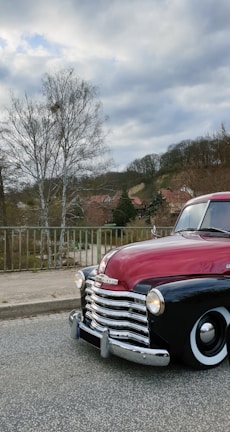 Classic Chevy Tahoe in racing red parked beside a Texas ranch fence at sunset.
