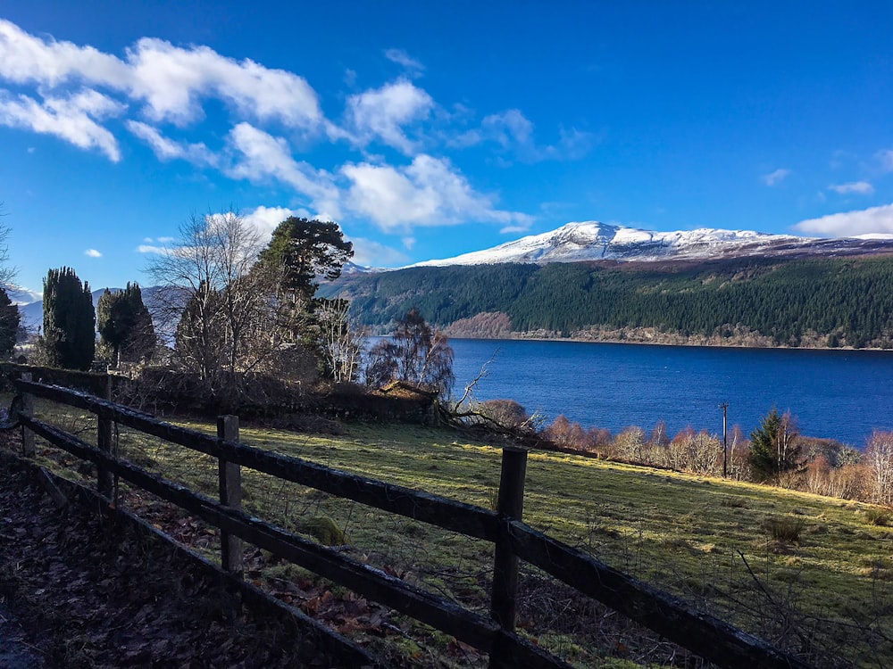 a wooden fence next to a large body of water