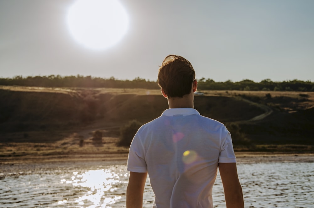 a man standing in front of a body of water