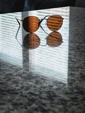 A pair of Cairn sunglasses resting on a textured surface with subtle reflections