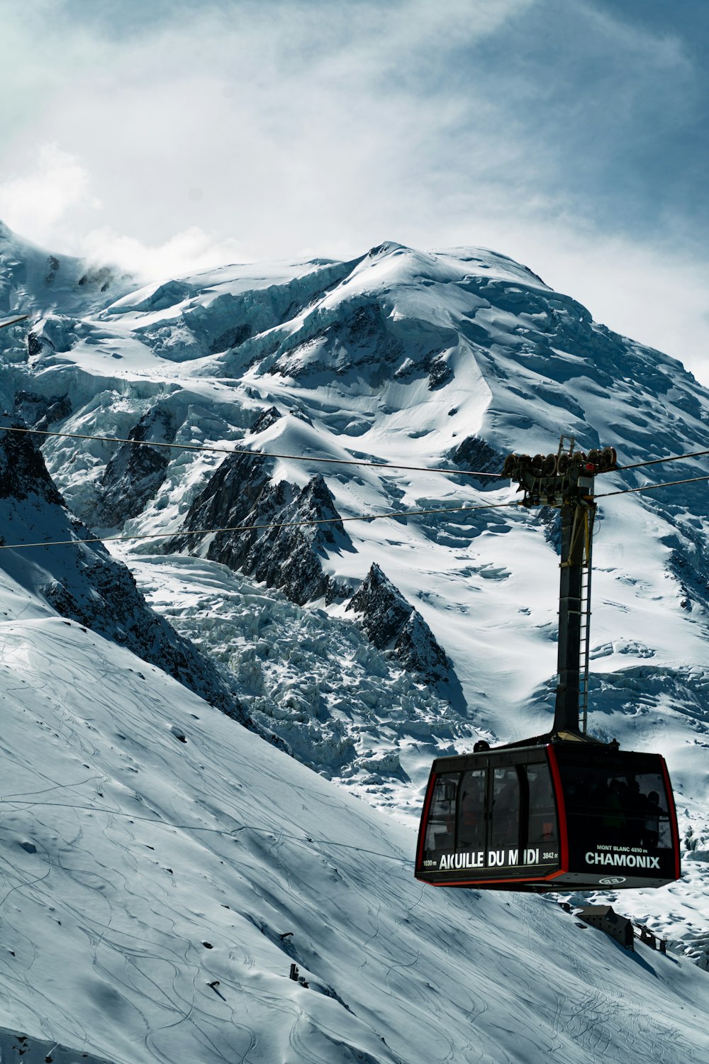 a ski lift going up the side of a snow covered mountain