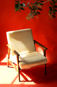 A beautifully restored vintage chair with fresh paint and polished wood, spotlighted in natural light.
