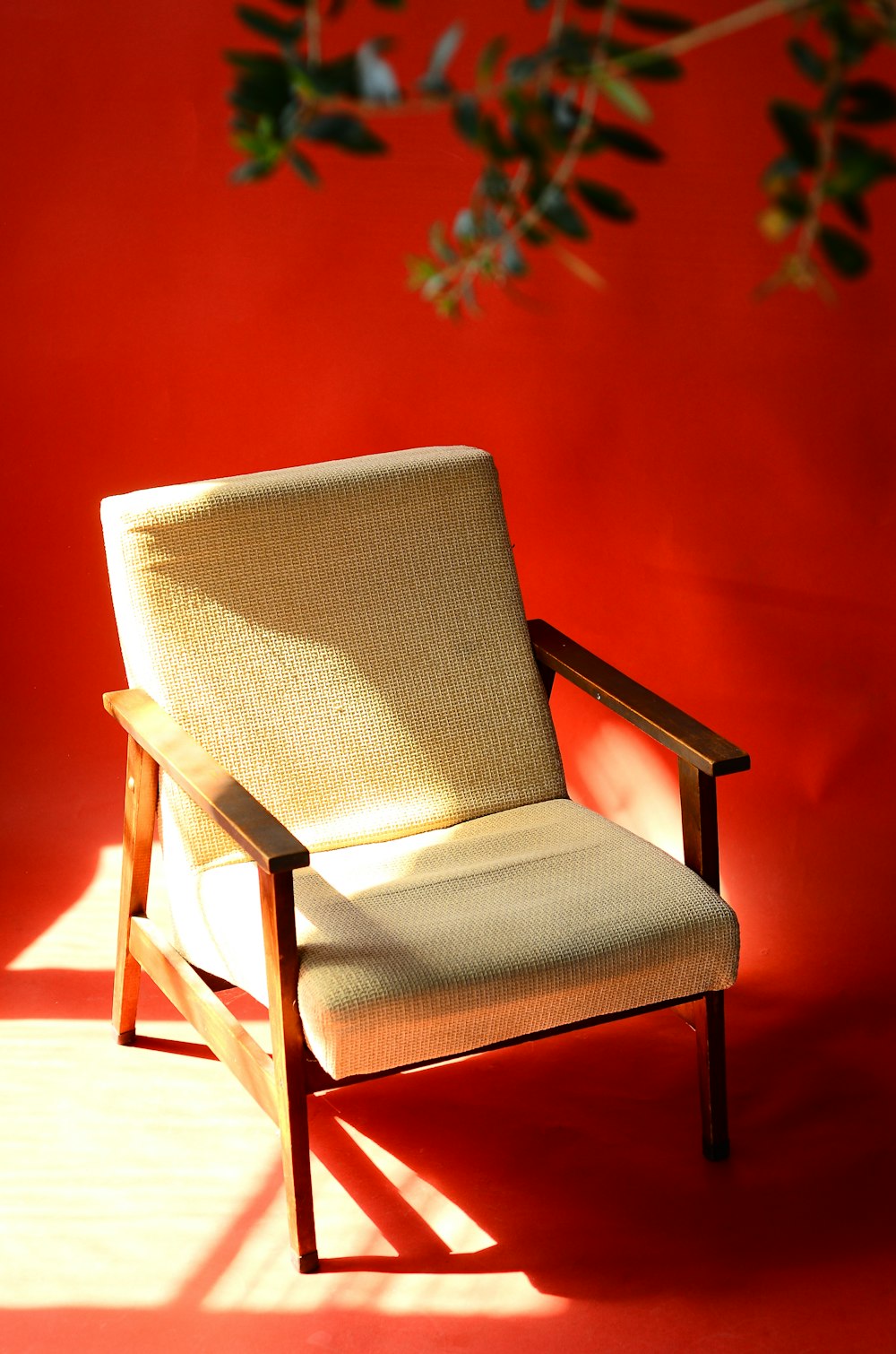 a chair sitting in front of a red wall