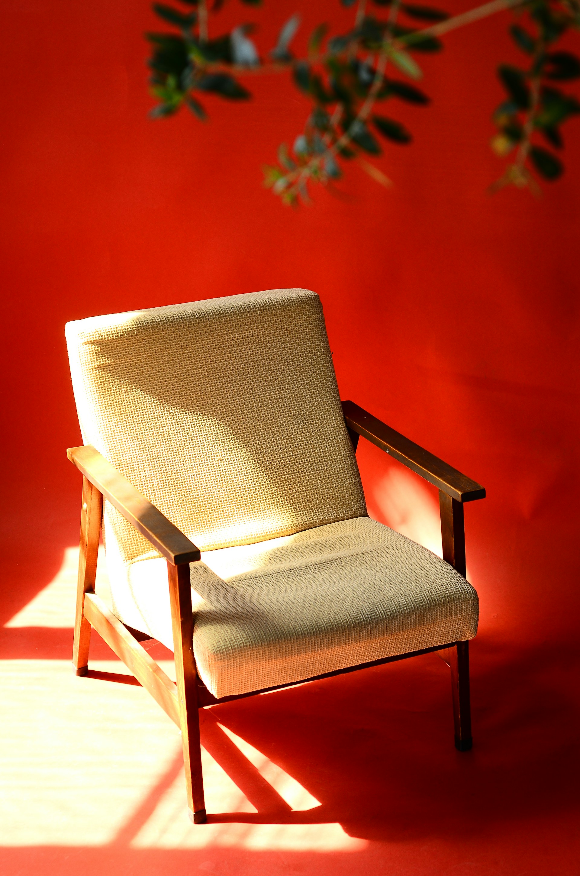 a chair sitting in front of a red wall