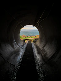a dark tunnel with a view of the ocean