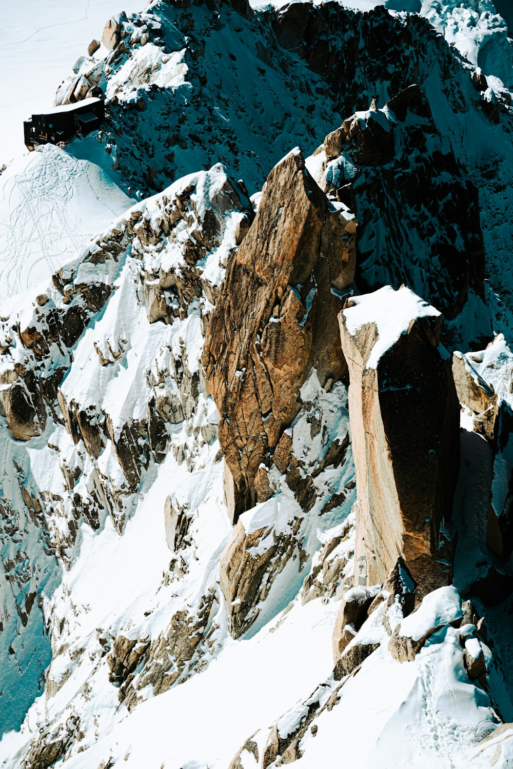 a snow covered mountain with a snowboarder on it