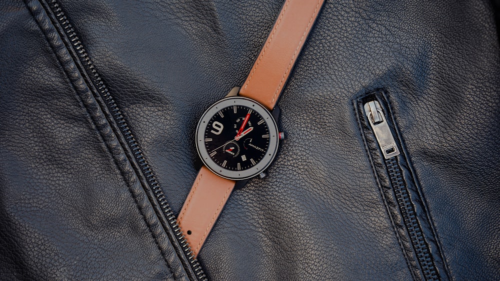 a watch on a leather strap on a jacket