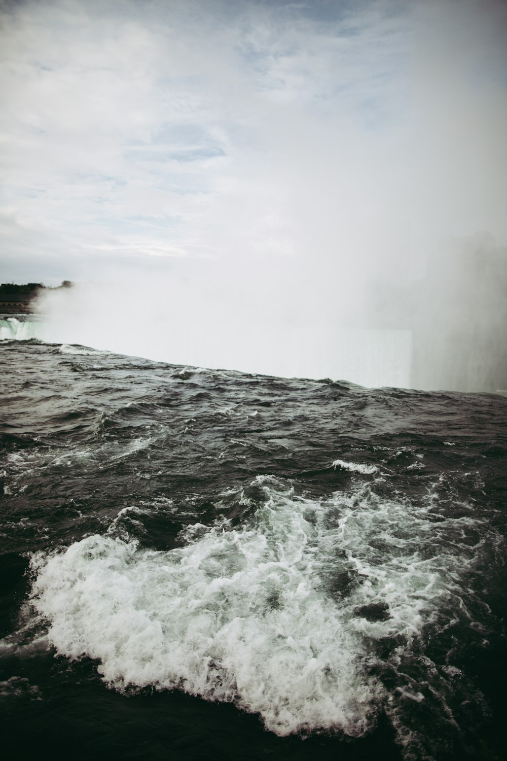 a large body of water with a waterfall in the background