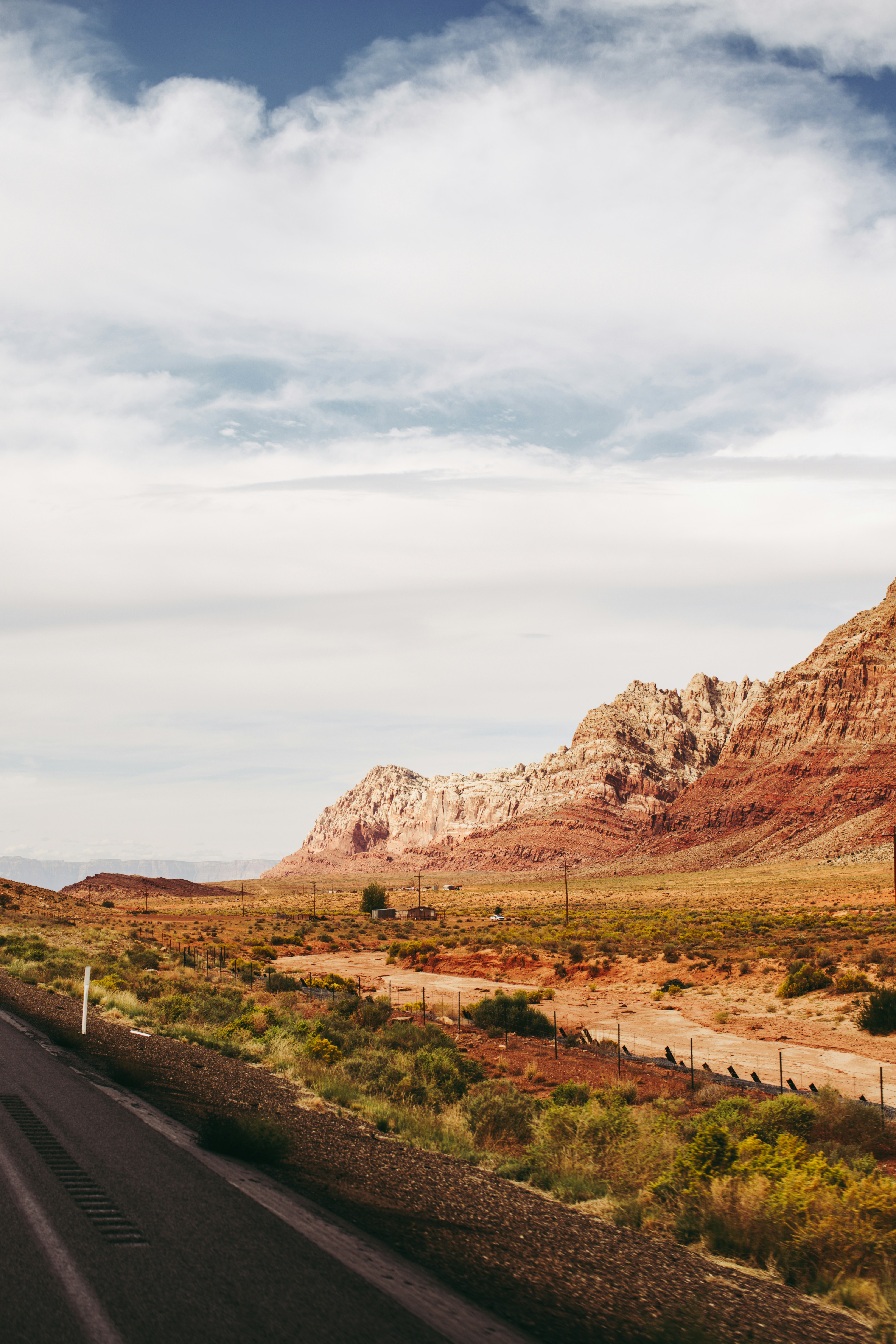a road in the middle of a desert with a mountain in the background