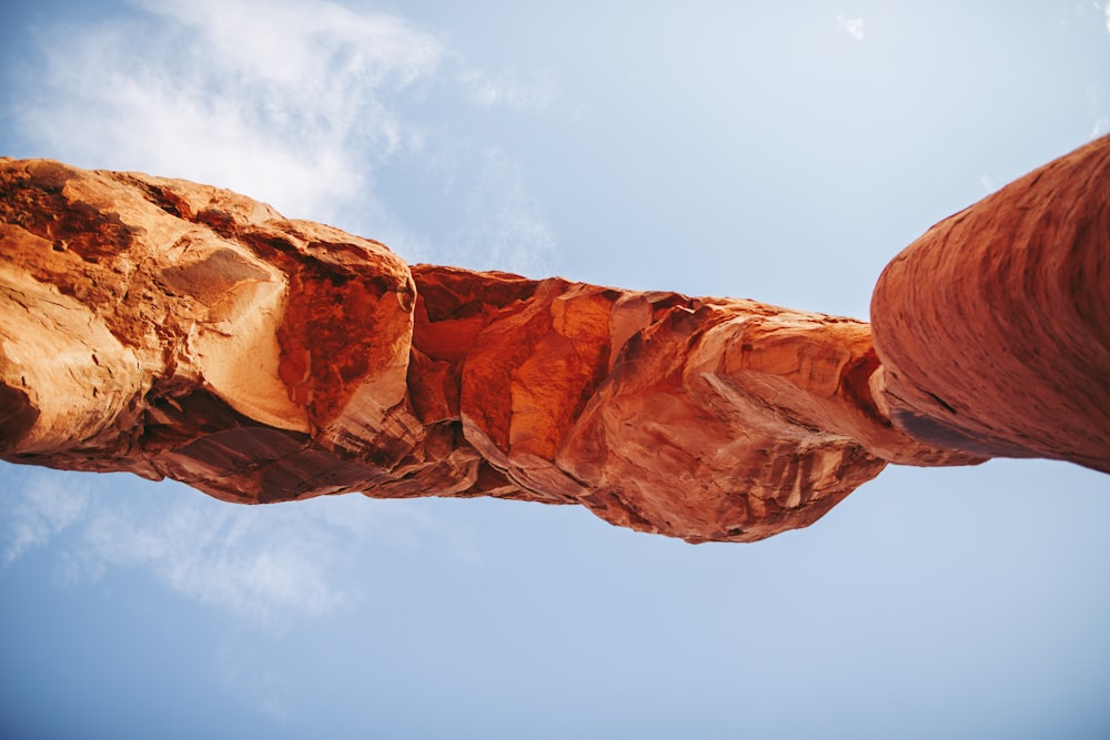 a very tall rock with a sky in the background