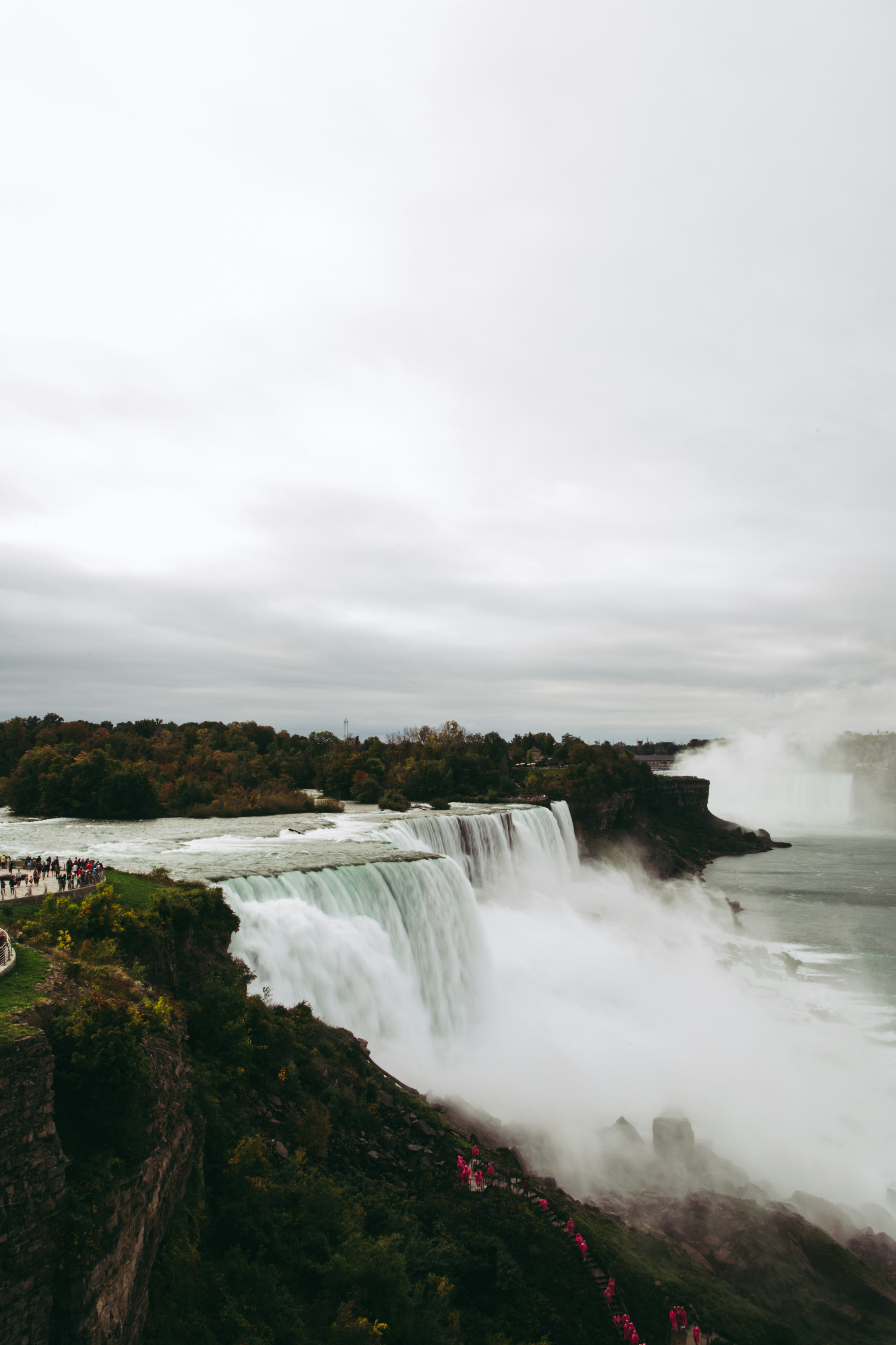 a group of people standing on the side of a waterfall