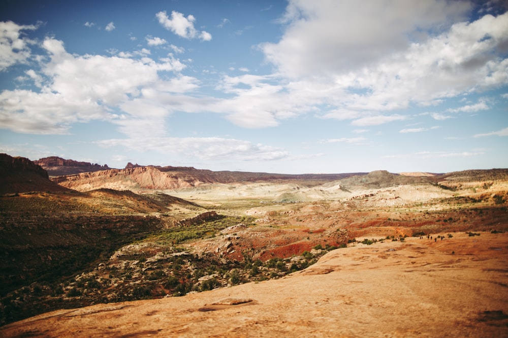 a scenic view of a valley with mountains in the background