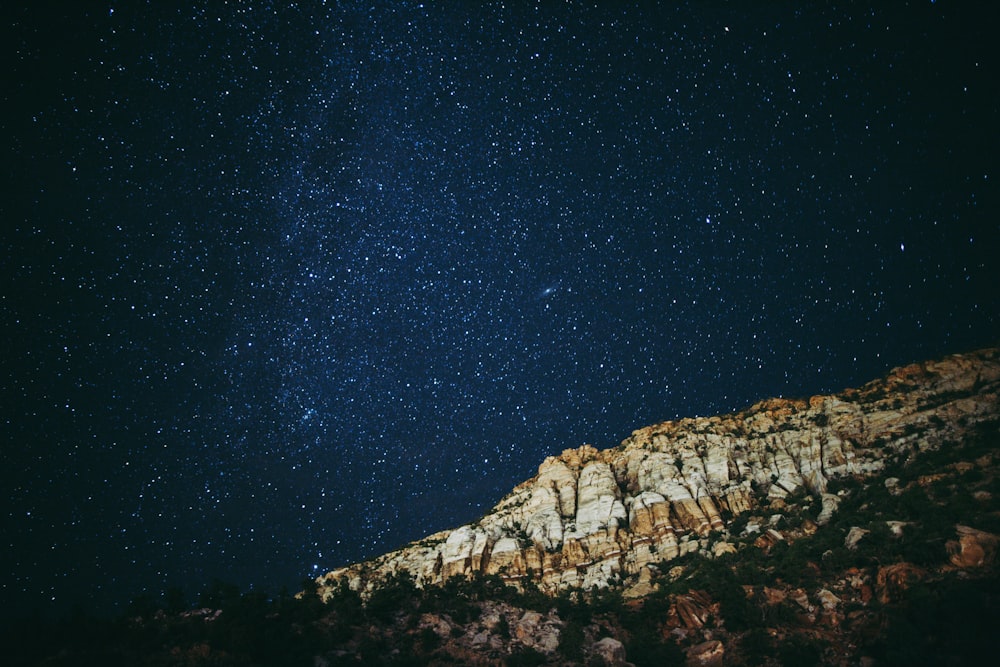 the night sky is filled with stars above a mountain