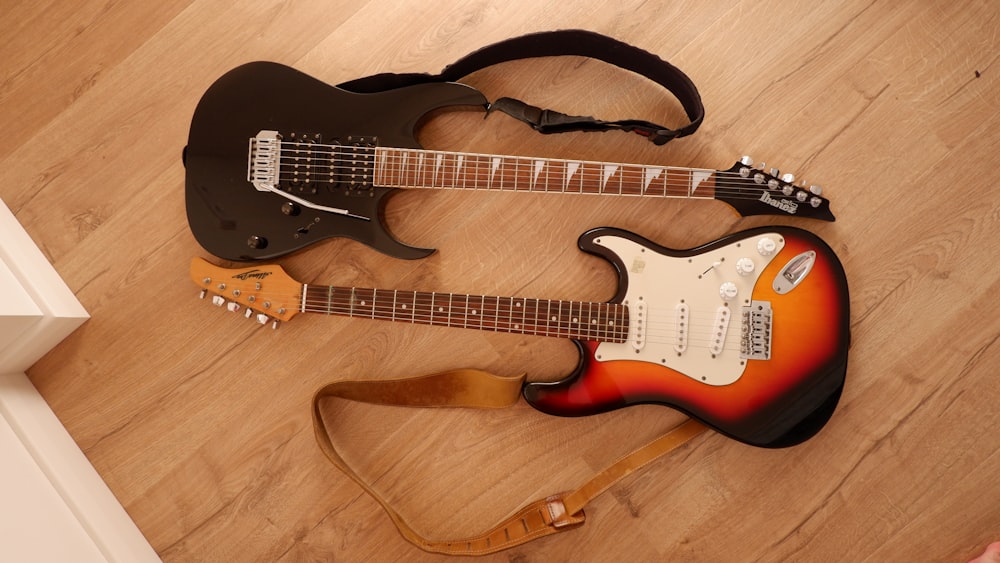 two guitars sitting on the floor next to each other