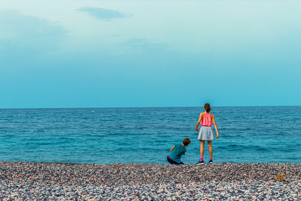 a woman and a child standing on a beach