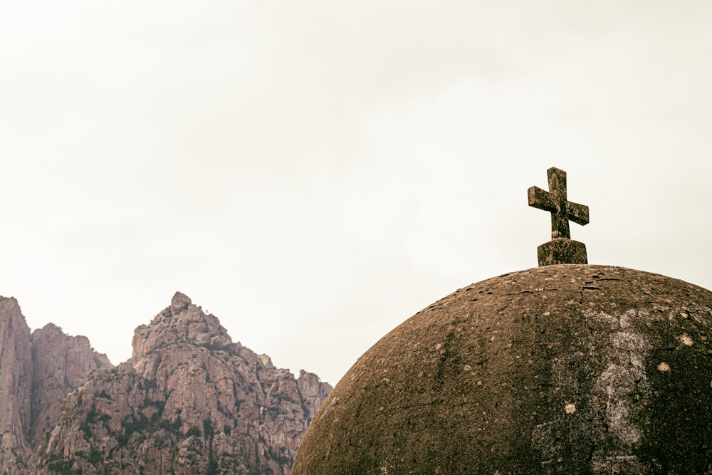 a cross sitting on top of a large rock