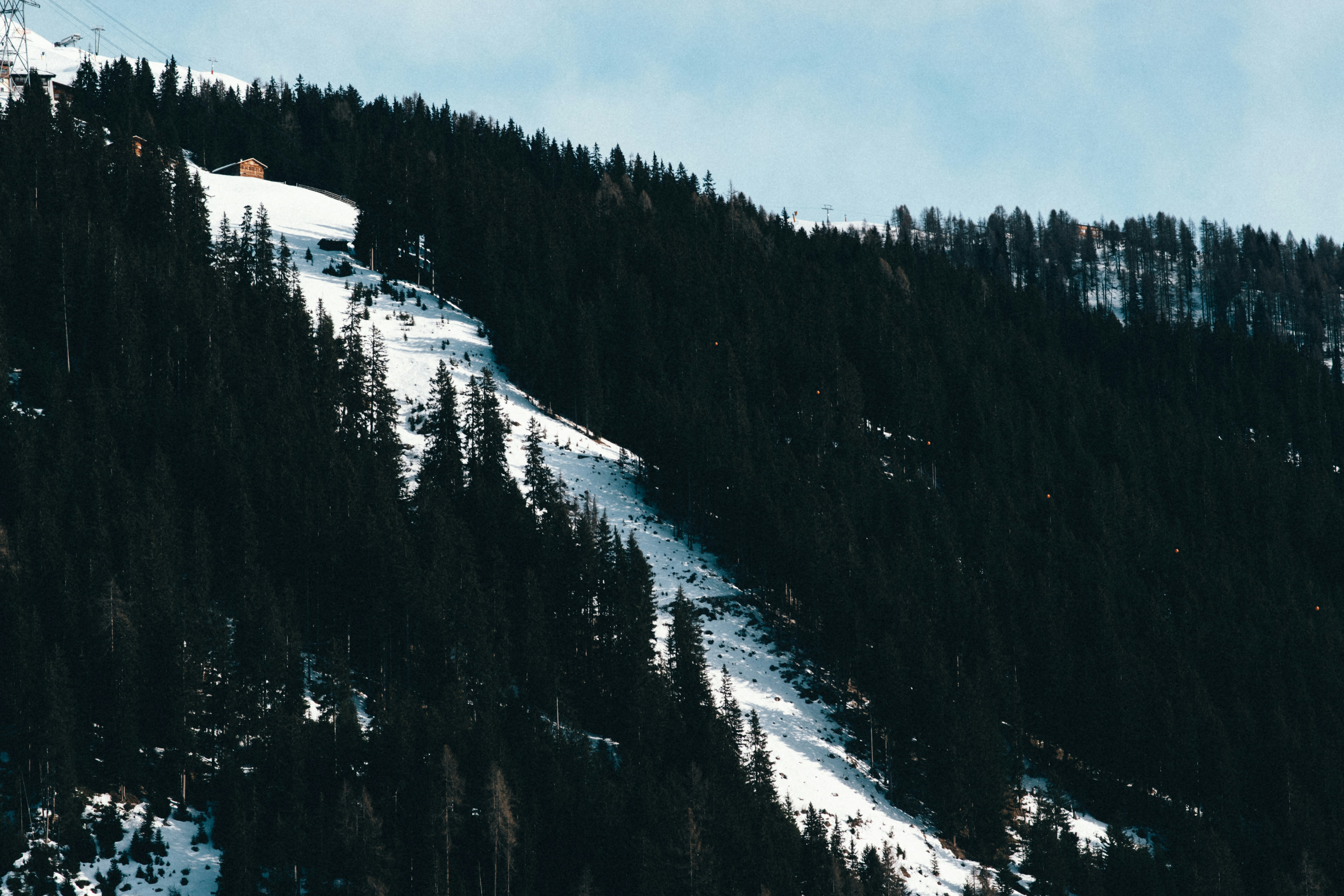 a snow covered mountain with a ski lift in the distance