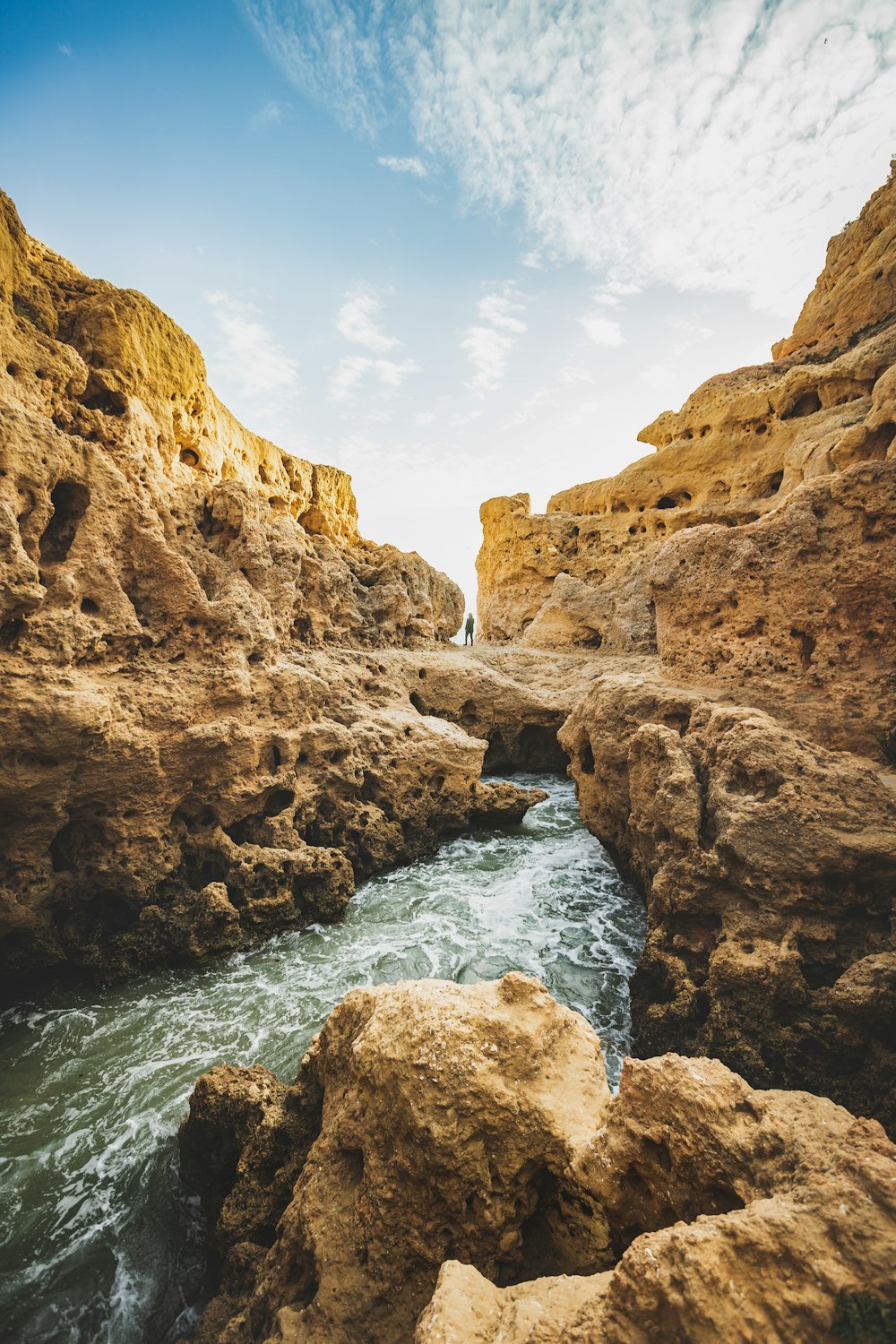 a river flowing through a rocky canyon under a blue sky
