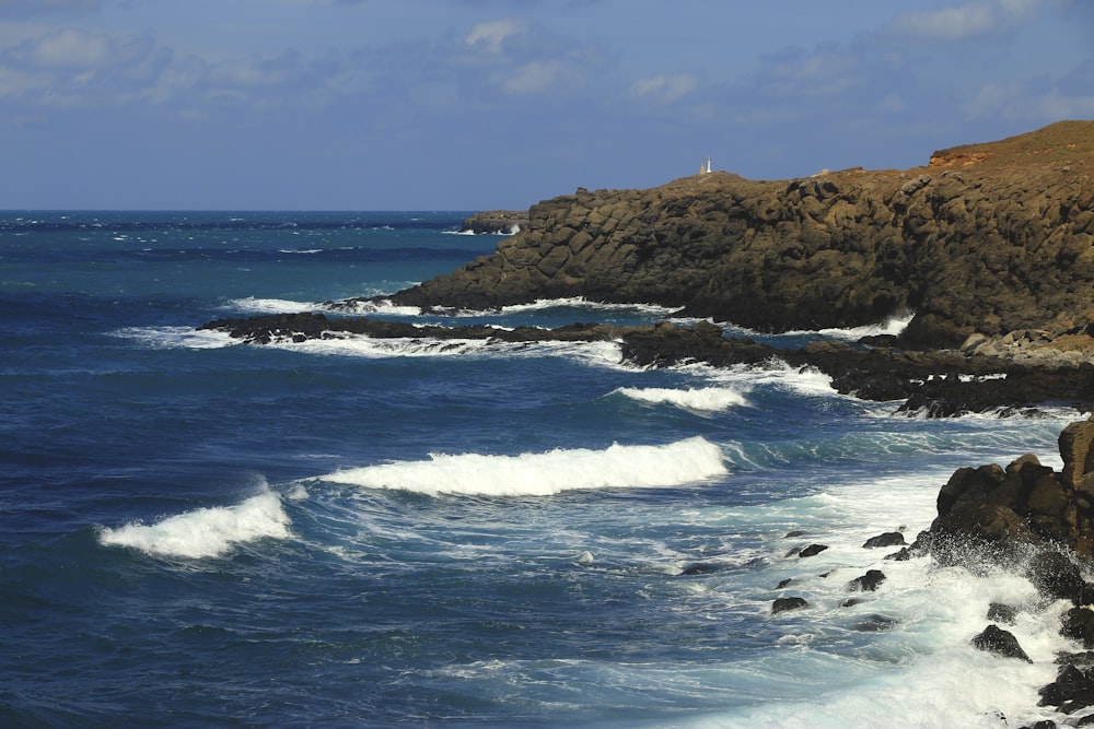 uma costa rochosa com ondas batendo contra as rochas