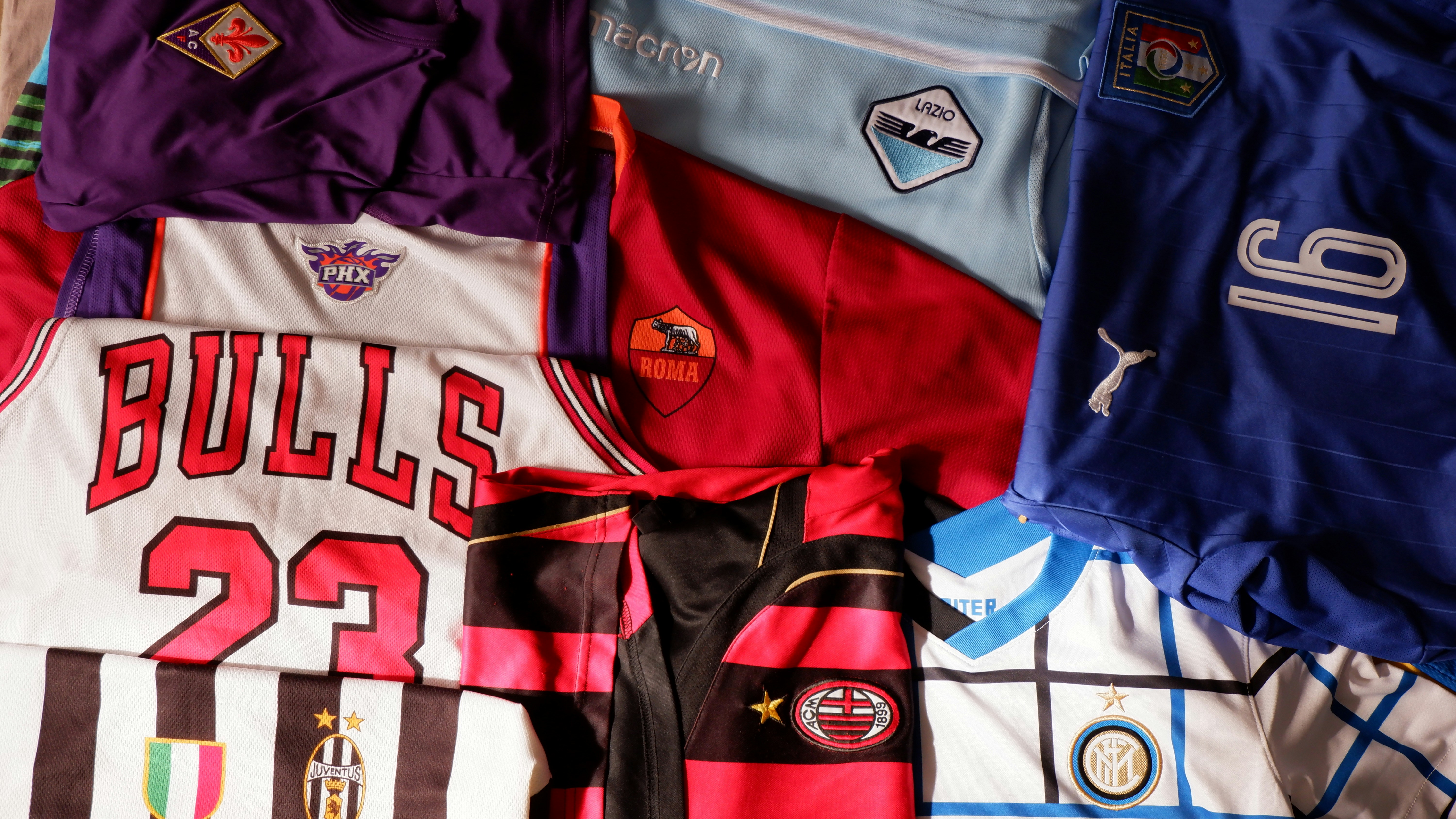 A lot of sports shirts from Serie A and NBA teams. Tops of calcio: AC Milan, FC Internazionale, AS Roma, SS Lazio, ACF Fiorentina and national Italy football team. NBA teams perfomed by Phoenix Suns and Chicago Bulls.