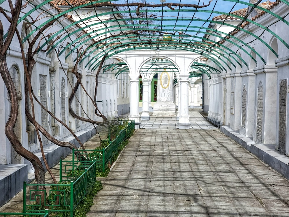 a walkway in a building with green railings