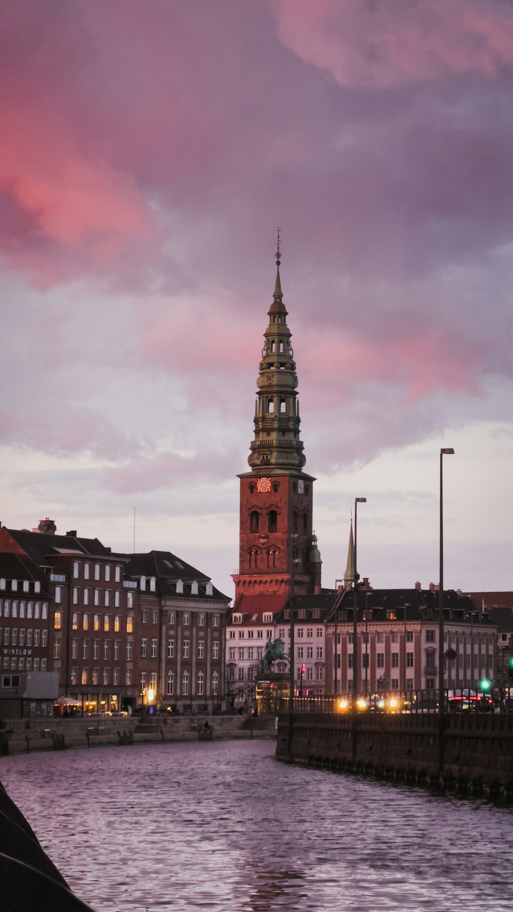 a large clock tower towering over a city next to a river