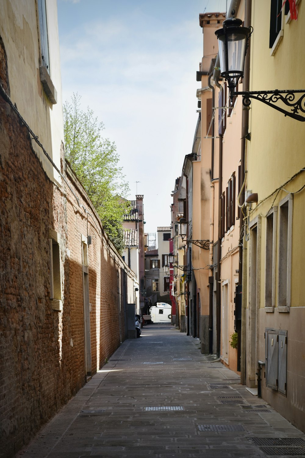 a narrow street with a car parked on the side of it